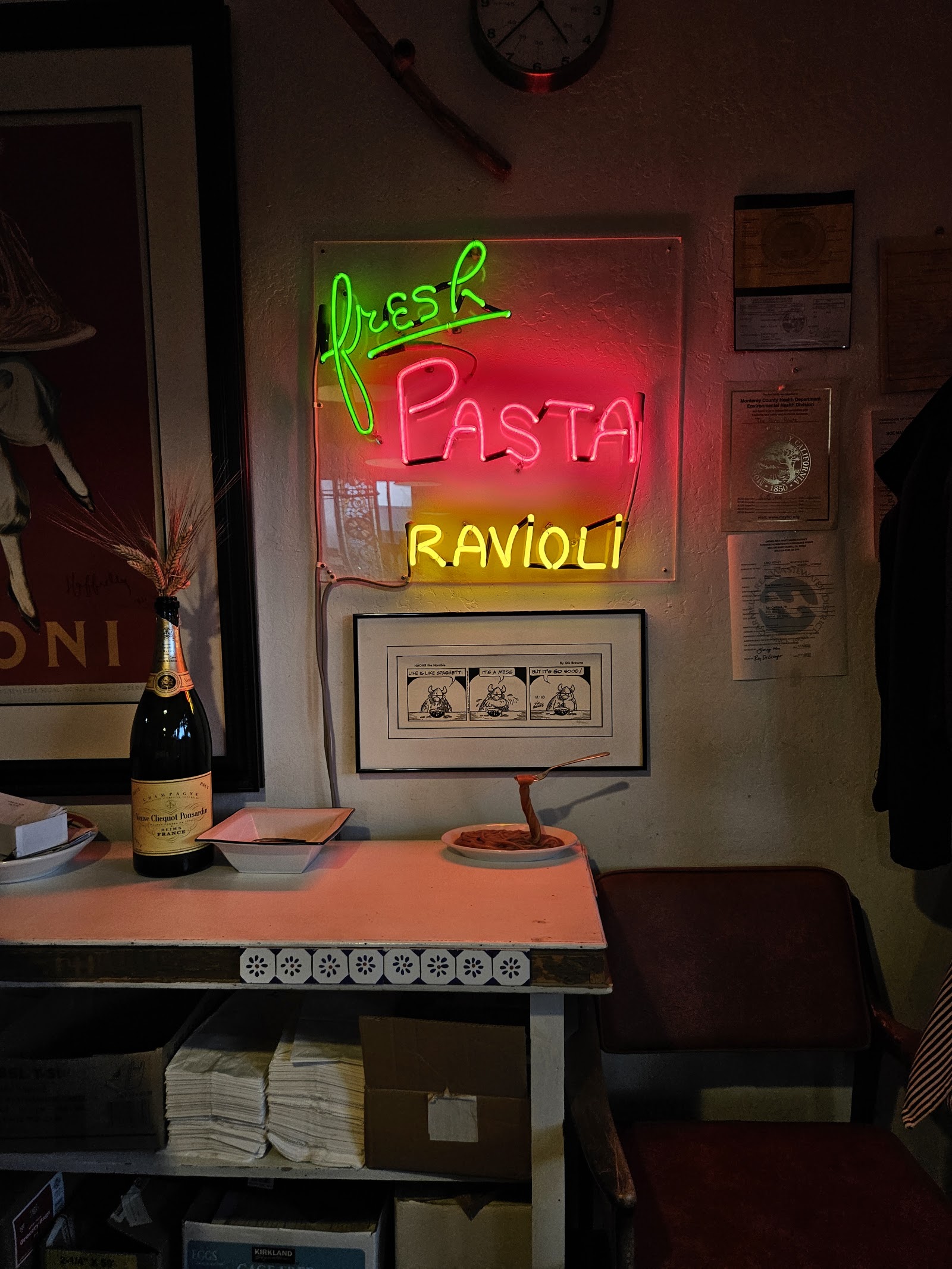 Plated pasta beneath a Fresh Pasta Ravioli sign